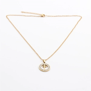 Macro detail of gold stainless steel cross pendant necklace with sparkling crystal inlay