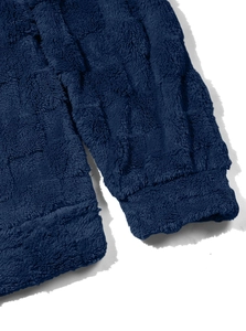 Detail of soft navy blue fleece fabric with elastic cuffs and double-stitched hem texture