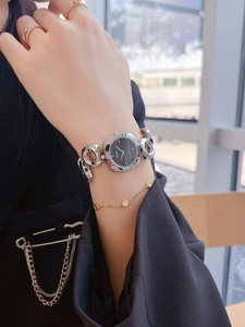 Detailed view of silver hollow chain bracelet watch with black dial on female wrist