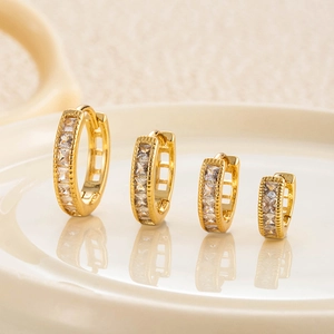 Élégantes créoles carrées en zircon plaqué or en quatre tailles sur une assiette en céramique