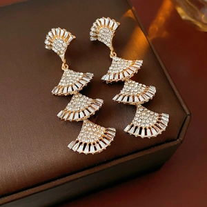 Detailed macro of gold-tone multi-layered fan-shaped tassel earrings with inlaid rhinestones