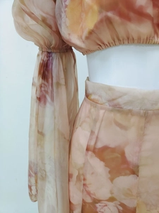 Detailed view of floral print chiffon crop top with translucent sleeves and stitching