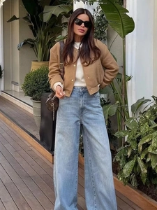 Y2K brown cropped bomber jacket with stand collar and pockets paired with wide leg jeans