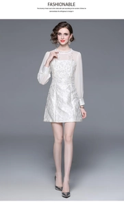 Detail of white long-sleeved dress with intricate lace embroidery and floral patterns