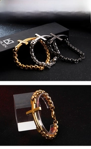 Close-up of cross pendant bracelets in gold, silver, and black polished stainless steel