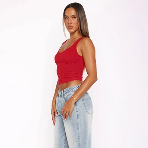 Seitenansicht eines roten, schmal geschnittenen Crop-Tops mit hellblauer Denim-Jeans