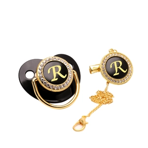 Luxurious black and gold baby pacifier set with rhinestone letter R and metal chain