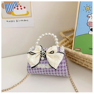 Detail of girls' purple houndstooth mini bag with pearl handle and lace bow decoration