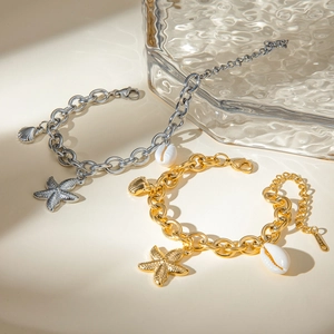 Detail of starfish and seashell charms on gold and silver stainless steel bracelets