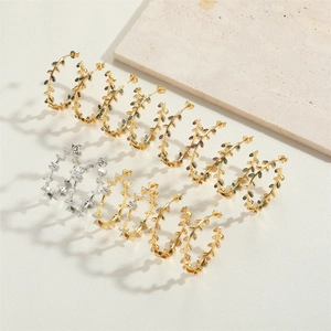 Close-up of 14K gold leaf design earrings with colorful zircon stones on white background