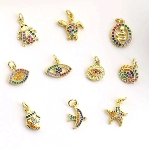 Flat lay of colorful cubic zirconia charms including evil eye, turtle and starfish shapes