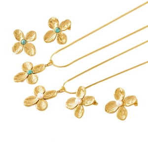 Gold clover jewelry set featuring turquoise and pearl necklaces with matching earrings
