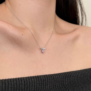 Close-up of S925 silver necklace featuring a pink heart zircon pendant on a model's neck