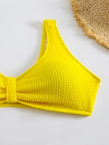 Detail of bright yellow seersucker bikini top with ruched texture and wide straps
