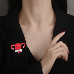 Cartoon uterous enamel pin with cuterus text on model lapel of a black blazer