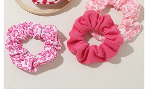 Detailed view of pink scrunchies with floral patterns and striped texture on a tray
