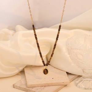 Close-up of golden Tiger Eye stone necklace with beads and heart pendant on silk