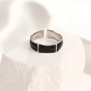 Close-up of silver adjustable ring featuring three black enamel rectangle geometric details
