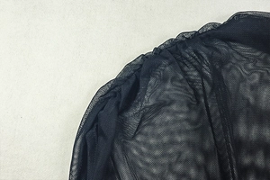 Close-up of black mesh fabric detailing with pleated texture on the slim fit dress