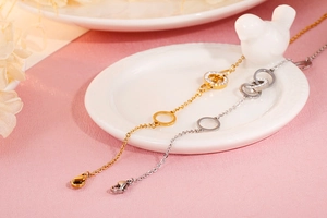 Detail of gold and silver interlocking ring necklaces with pave zircon in a ceramic tray
