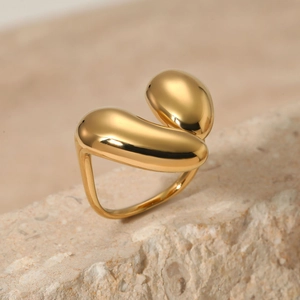 Irregular organic golden stainless steel ring on natural stone for a minimalist look