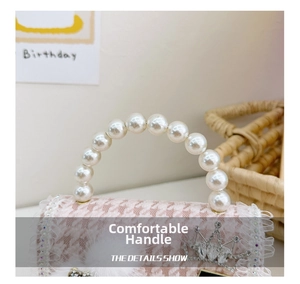 Detailed view of pearl handle with lace trim and rhinestone crown on pink plaid bag