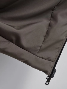 Detailed close-up of dark coffee padded coat featuring windproof fabric and black zipper
