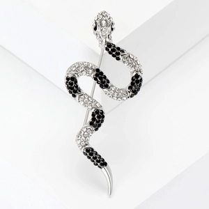 Macro shot of silver snake brooch with inlaid black and white rhinestones on white background