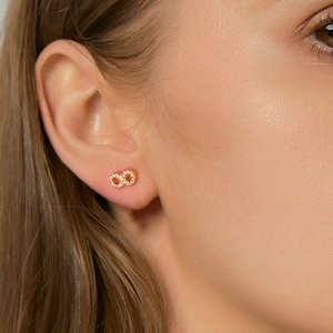 Elegant s925 gold plated infinity stud earrings with white pavé cubic zirconia on model