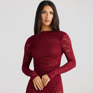 Détail de la robe en dentelle rouge à manches longues montrant le motif floral