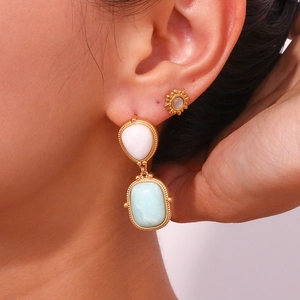 Vintage geometric drop earrings with teardrop stone and gold trim on female model