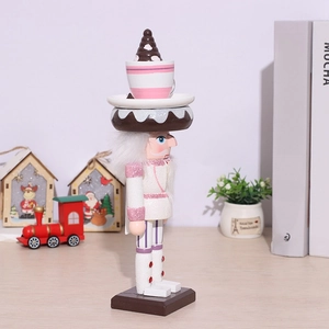 Pink glitter nutcracker chef soldier holding a tray with a miniature dessert and cupcake