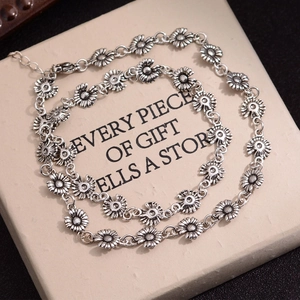 Vintage daisy flower necklace and bracelet set in antique silver finish on a display card