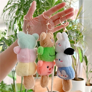 Detailed view of three stacked plush animal keychains in various cute character colors