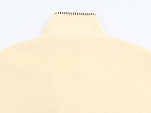 Detailed close-up of cream fleece coat neckline with contrasting black decorative stitching