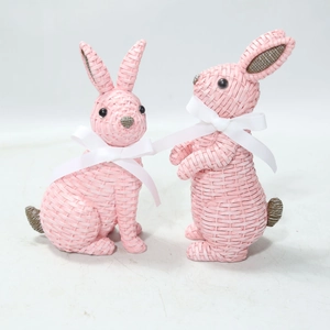 Detail of pink resin rabbit figurines with woven texture and white ribbon bows