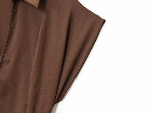 Detalle de cerca de la textura de la tela tejida marrón oscuro y el escote del vestido