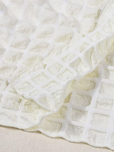 Detailed view of high-waist skirt fabric featuring cream white bubble texture and stitching