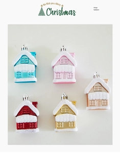 Detail of colorful metallic house ornaments for Christmas tree with snowy roof texture