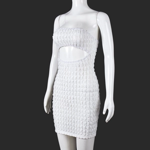 Détail d'une robe moulante blanche ajourée avec texture froncée et découpe à la taille