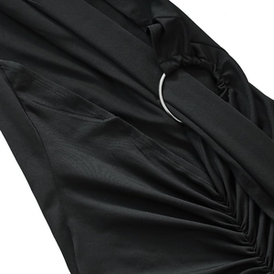 Detail of black dress featuring a silver metal ring connector and ruched cutout fabric
