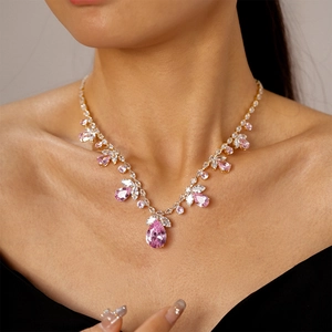 Vue détaillée du collier de luxe avec grand zircon rose en goutte et accents blancs