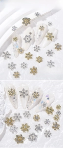 Detailed view of alloy snowflake nail charms with AB diamonds on white acrylic nails