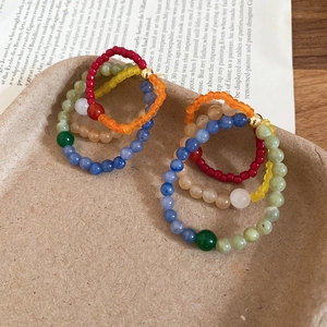 Macro view of bohemian multi-layered colorful bead hoop earrings on vintage background