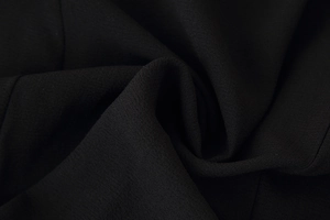 Detailed macro shot of high-quality black fabric texture with fine layered ruffles
