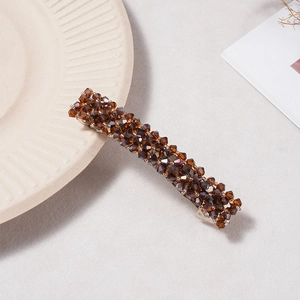Gros plan détaillé d'une barrette en cristal brun sur un fond texturé minimaliste