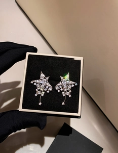 Macro view of sterling silver star earrings with brilliant cubic zirconia and tassel detail