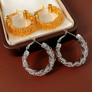 Detail view of gold and silver woven hoop earrings featuring complex mesh texture