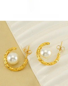 Close-up of 18K gold plated C-shaped earrings with central pearl and hammered texture