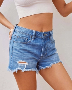 Gros plan sur un short en jean pour femme avec détails déchirés et ourlets à franges